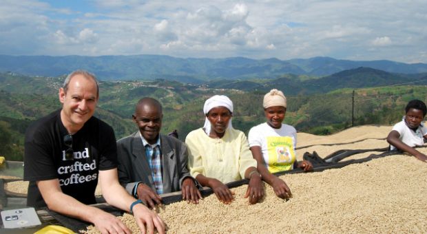 O Γιάννης Ταλούμης σε φάρμα της Ρουάντα, μπροστά σε άψητους κόκκους καφέ